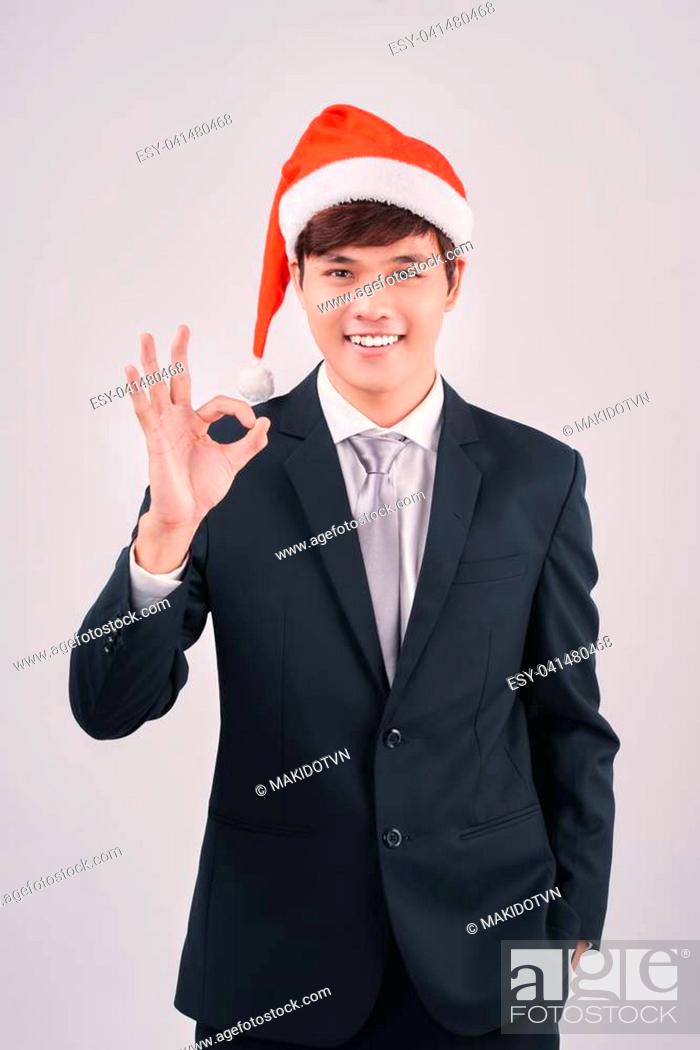 Stock Photo: Asian businessman celebrating christmas making the ok thumbs up sign.