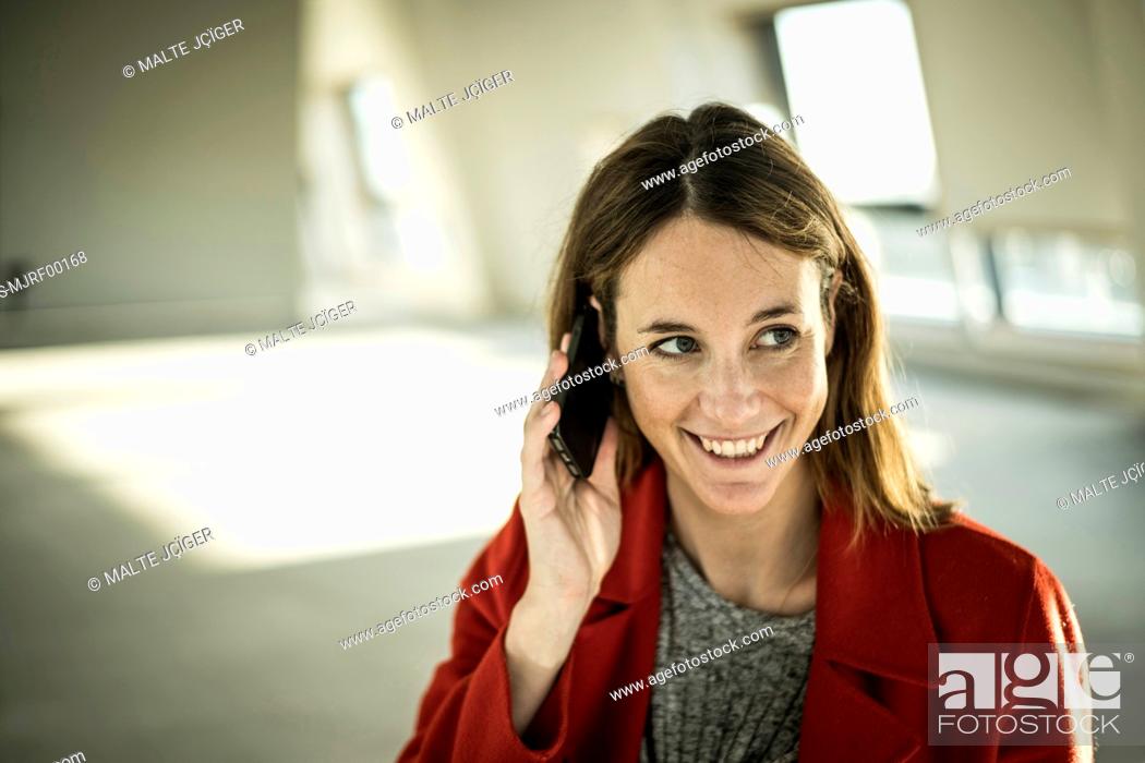Stock Photo: Businesswoman talking on the phone in new office rooms.