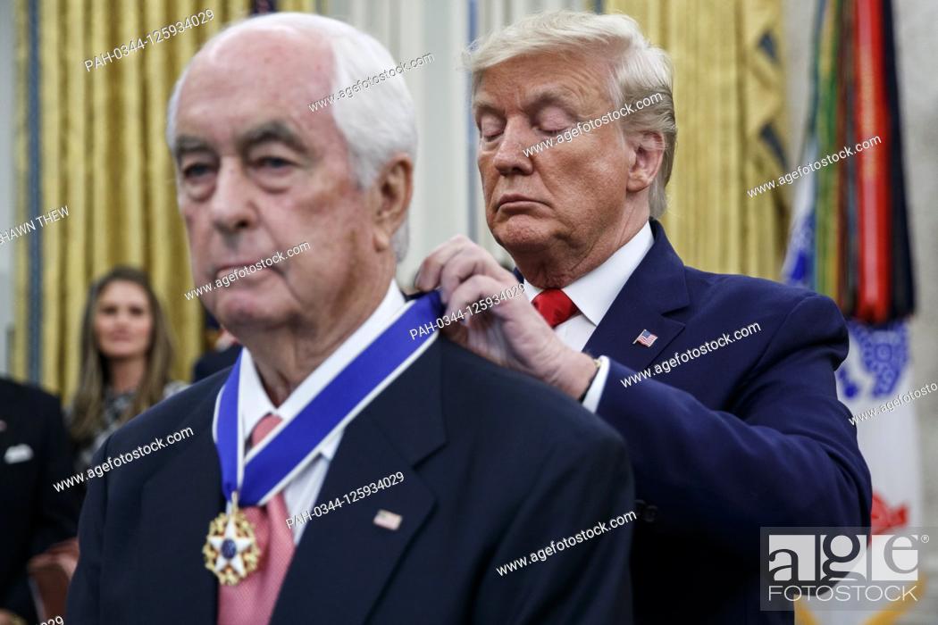 Stock Photo: US President Donald J. Trump (R) awards the Presidential Medal of Freedom to American racing magnate Roger Penske (L) during a ceremony in the Oval Office of.
