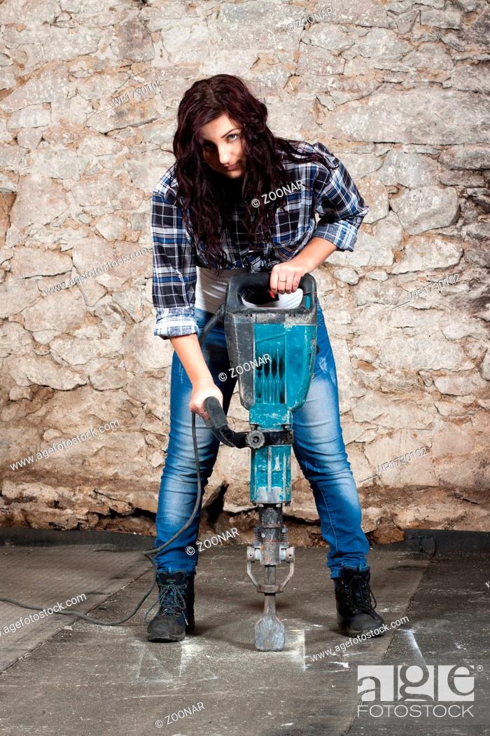 Stock Photo: Young long-haired woman with a jackhammer.