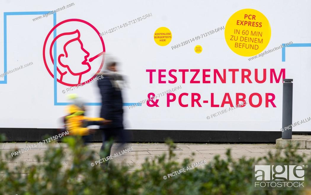 Stock Photo: 14 January 2022, Lower Saxony, Hanover: A woman and child walk past a testing center for the Corona virus (long-shutter speed shot).