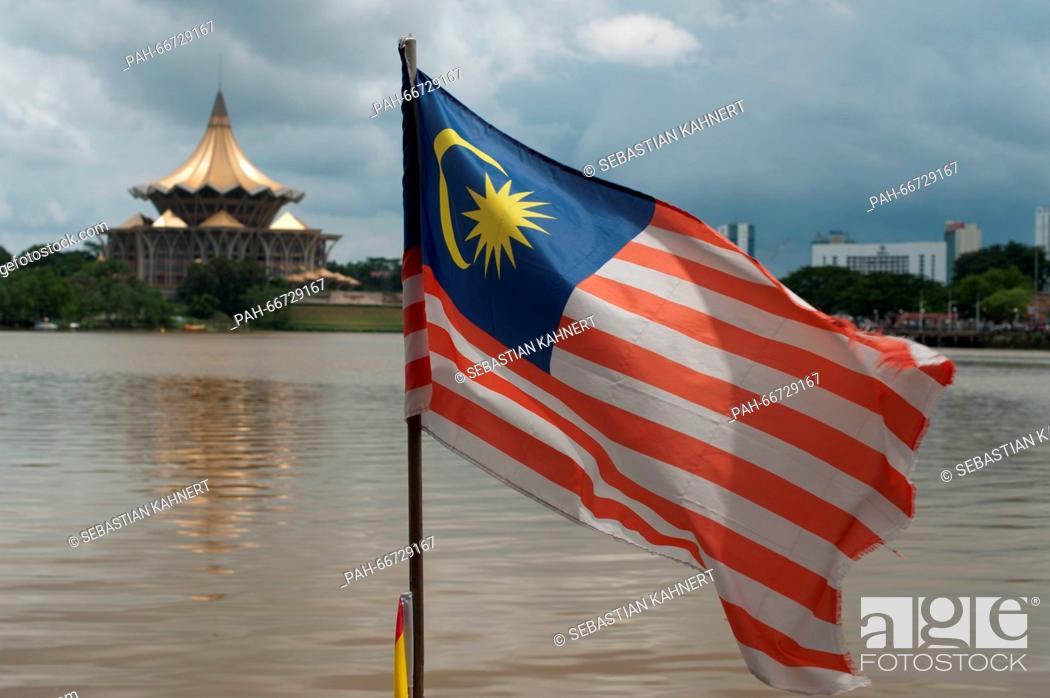 Stock Photo: The Malaysia flag is waving in the wind on the shore of the Sarawak River in front of the Sarawak State Legislative Assembly Building in Kuching, Malaysia.