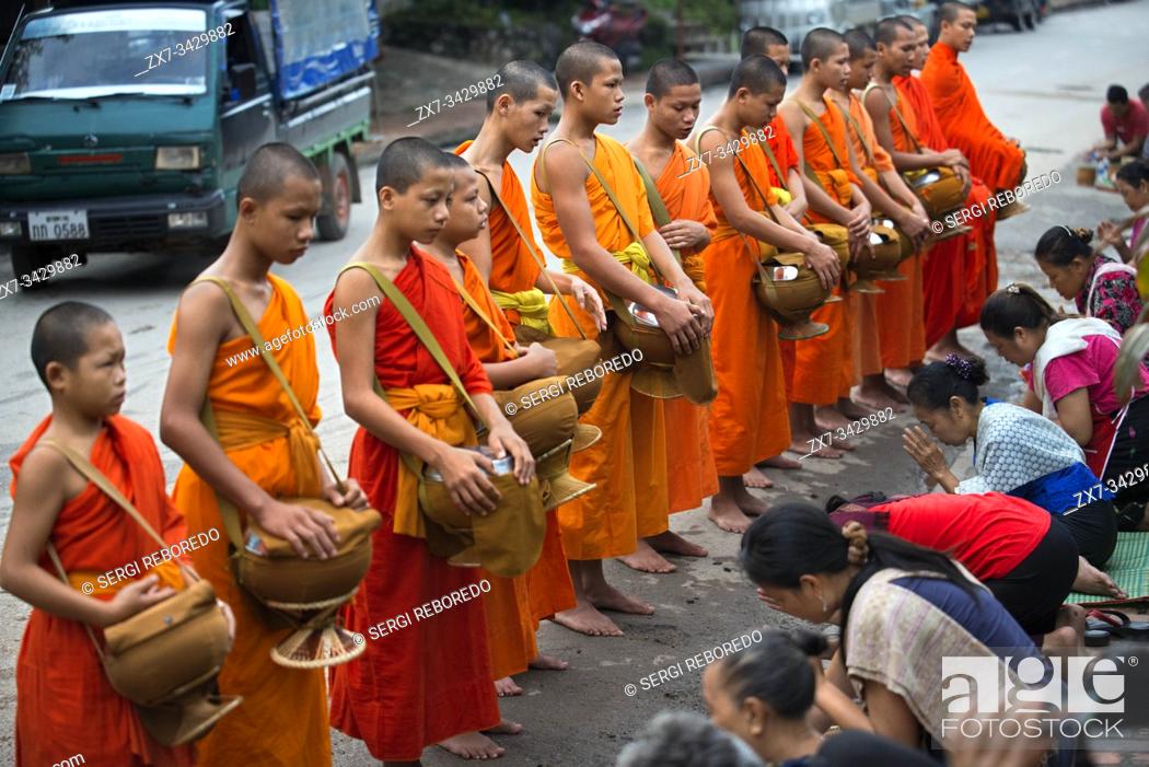 Stock Photo: Tak bat ritual - Buddhist monks receive rice and food from pupulation in early morning in Luang Prabang , Laos, Asia.