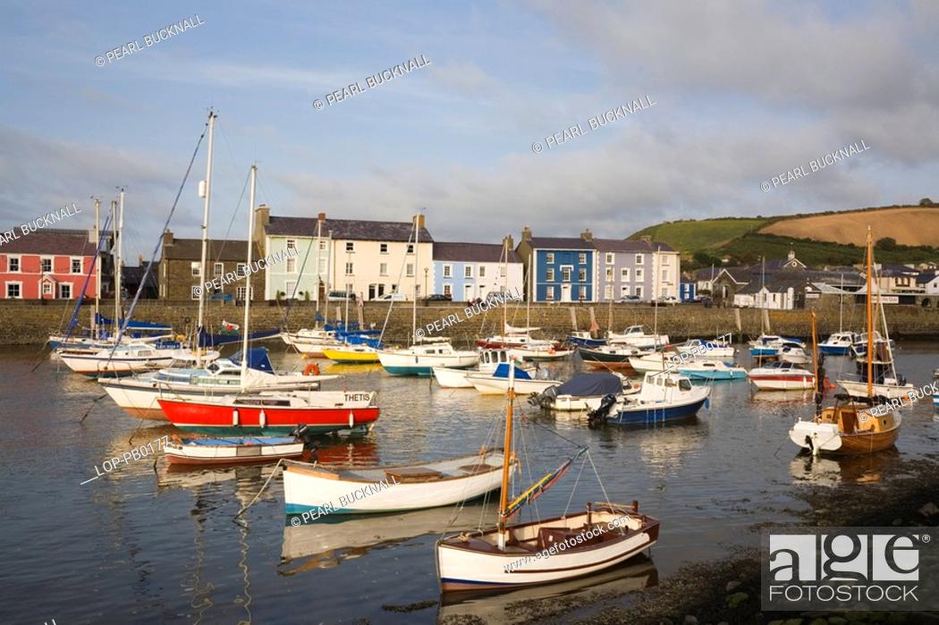 Stock Photo: Wales, Ceredigion, Aberaeron, View across Aberaeron harbour with boats moored and colourful Georgian houses reflected in the Afon Aeron river.