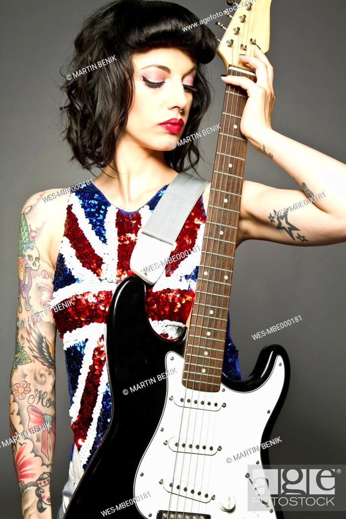 Young woman with guitar and tattoo on her hand against grey background,  Stock Photo, Picture And Royalty Free Image. Pic. WES-MBE000181 |  agefotostock