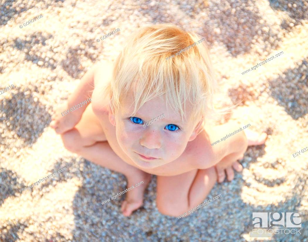 Little boy with blue eyes and white hair sitting on white sand and look up  at the camera, Stock Photo, Picture And Low Budget Royalty Free Image. Pic.  ESY-032229919 | agefotostock
