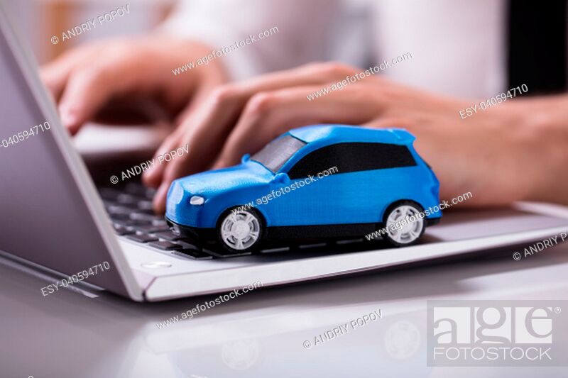 Stock Photo: Close-up Of A Small Blue Car On Laptop Keypad.