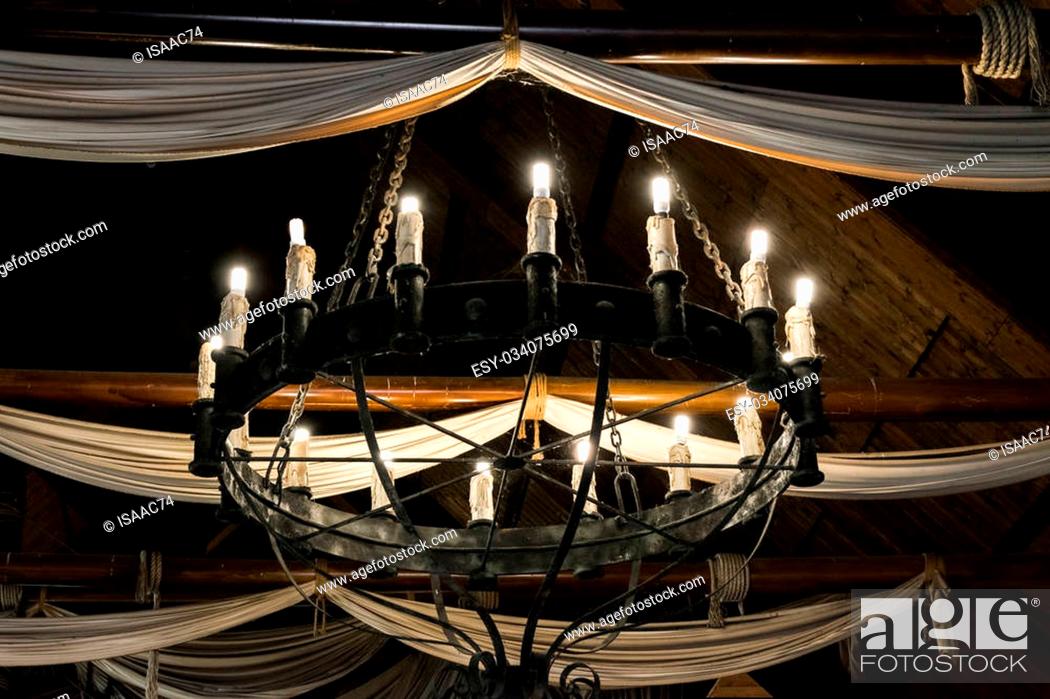 Stock Photo: Round iron chandelier in an old tavern.