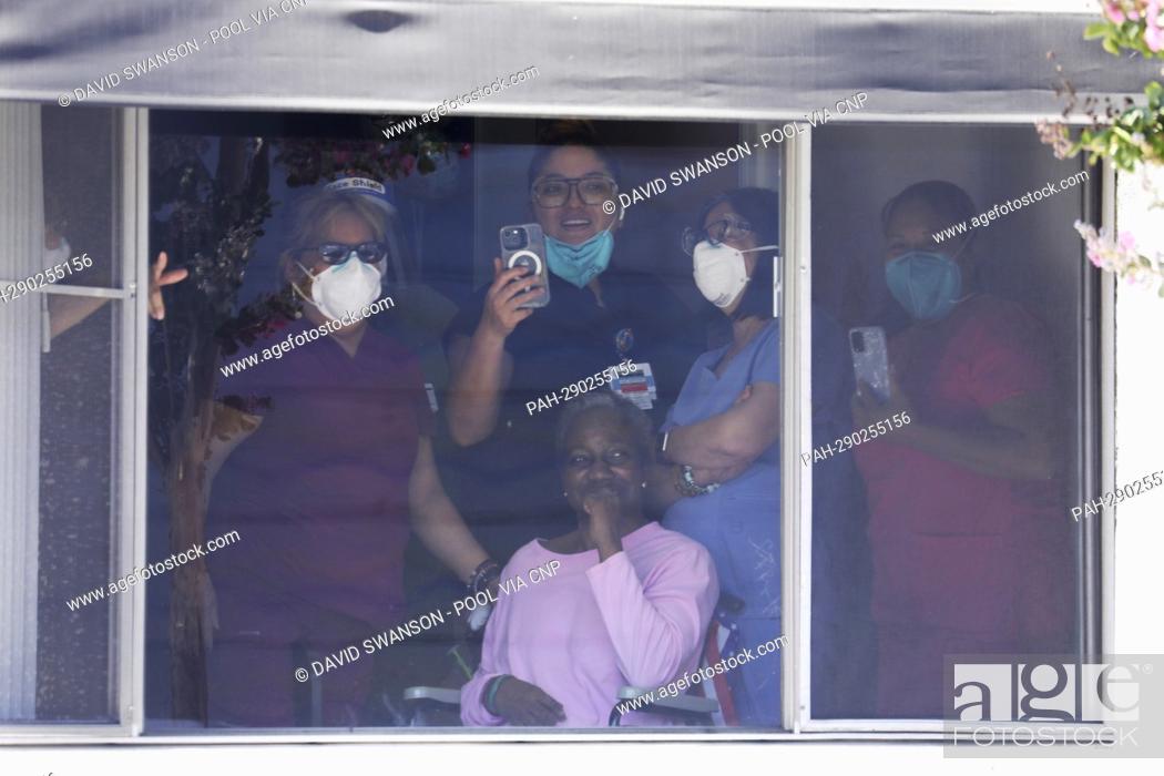 Stock Photo: Health care workers and patients watch from a window as US Vice President Kamala Harris enters the Los Angeles County Federation of Labor, AFL-CIO.