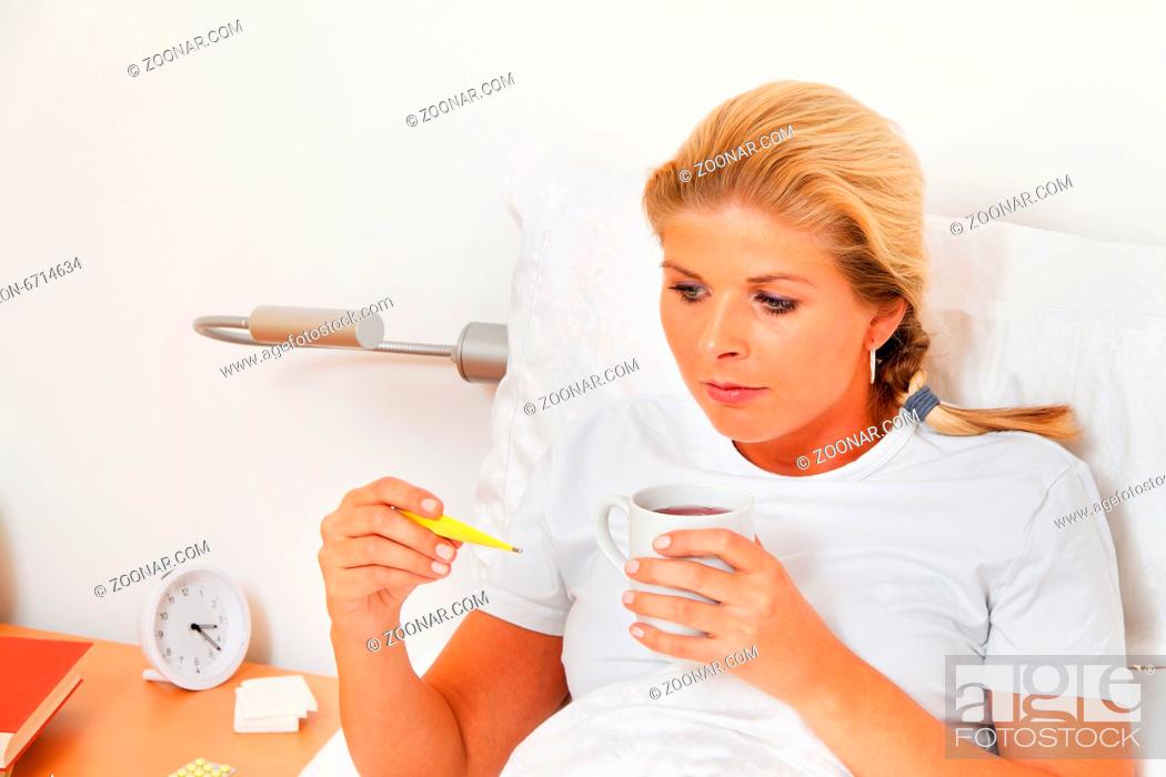 Stock Photo: Eine Frau im Bett ist Krank und hat Fieberthermometer.