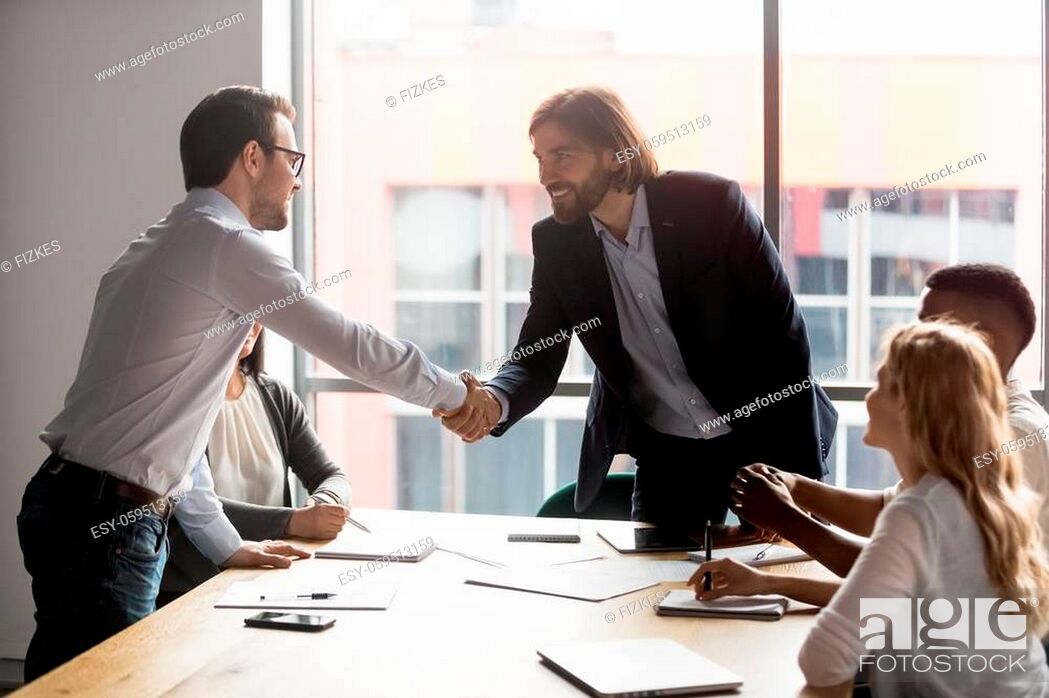 Stock Photo: Negotiation starts with businessmen leaders of business parties shake hands, boss greeting company client diverse businesspeople gathered together in modern.