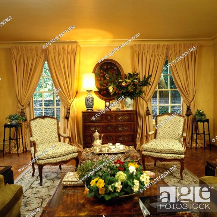 Yellow Curtains And Cream Chairs In