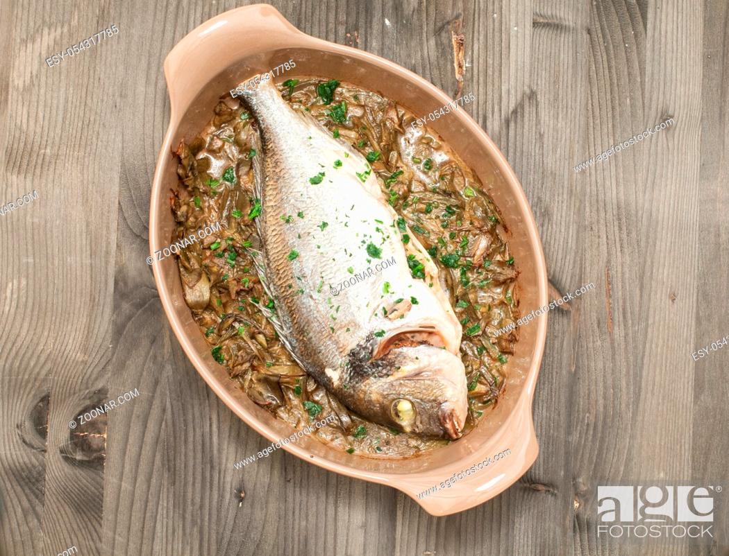 Stock Photo: Fish cooked bream baked with stewed artichokes, italy.