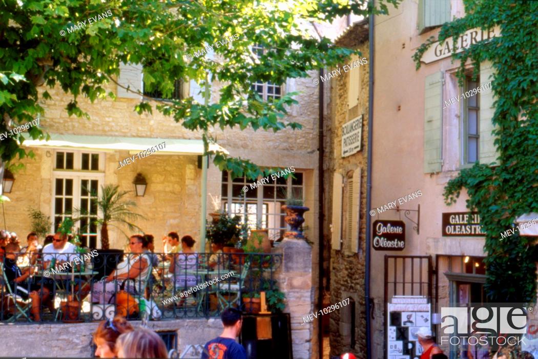 Stock Photo: Street scene at Isle sur la Sorgue, known as the Venice of Provence, France, on a sunny day, with people sitting at tables relaxing.
