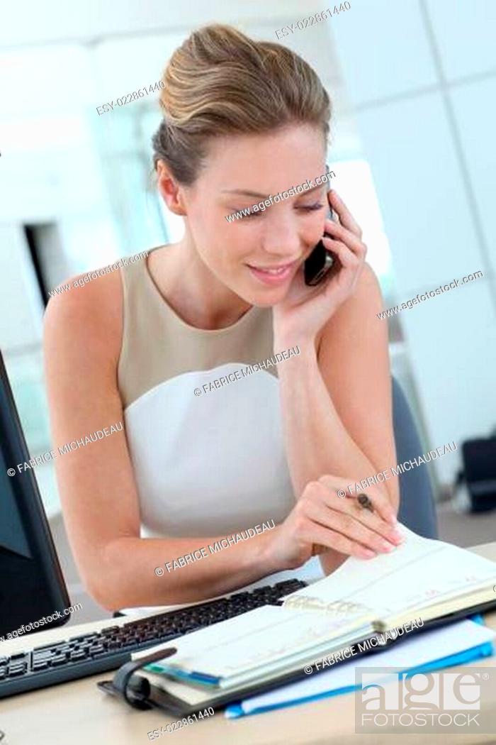 Stock Photo: Businesswoman at her desk booking meeting hours on agenda.