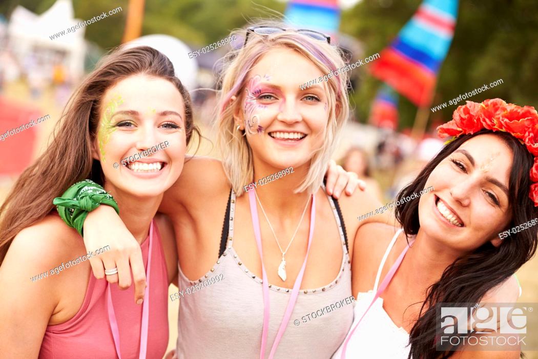 Stock Photo: Girl friends with arms around each other at a music festival.