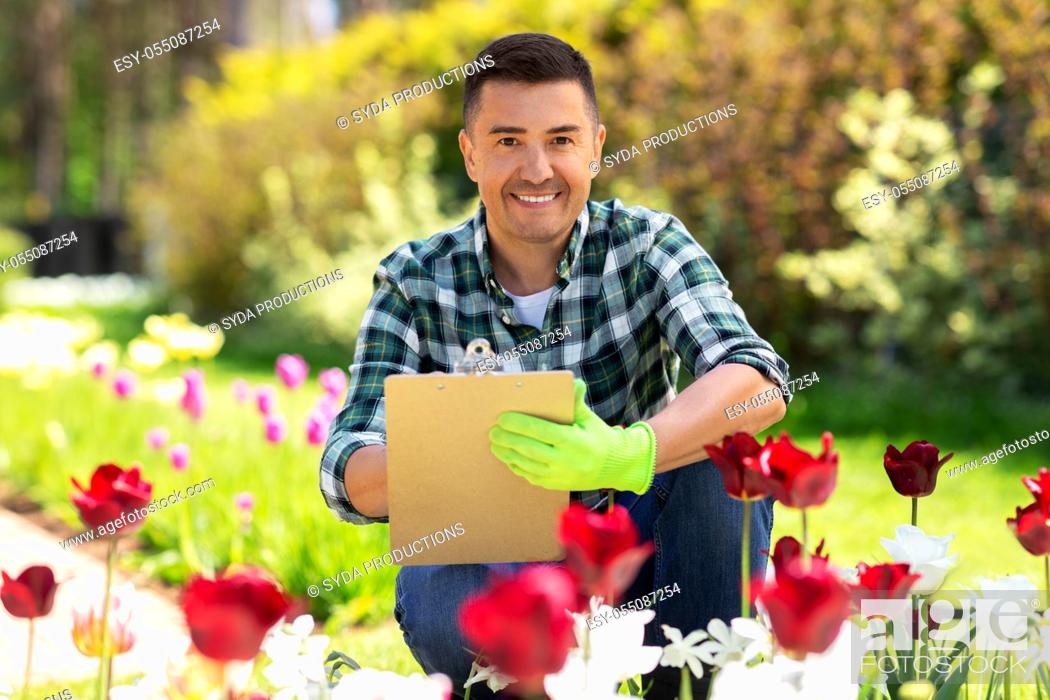 Photo de stock: man with clipboard and flowers at summer garden.