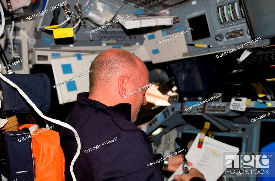 Stock Photo: Astronaut Scott Kelly, STS-118 commander, looks over procedures checklists on the flight deck of Space Shuttle Endeavour during flight day seven activities.