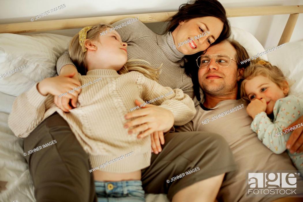 Stock Photo: Family lying in bed.