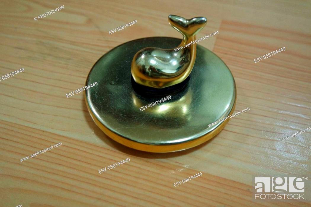 Stock Photo: The decorative little golden pot with dolphin lid open, for room decoration. Golden pot on the vintage white background.