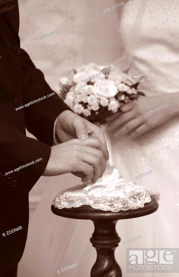 Stock Photo: Hands of the groom and the bride during wedding ceremony.