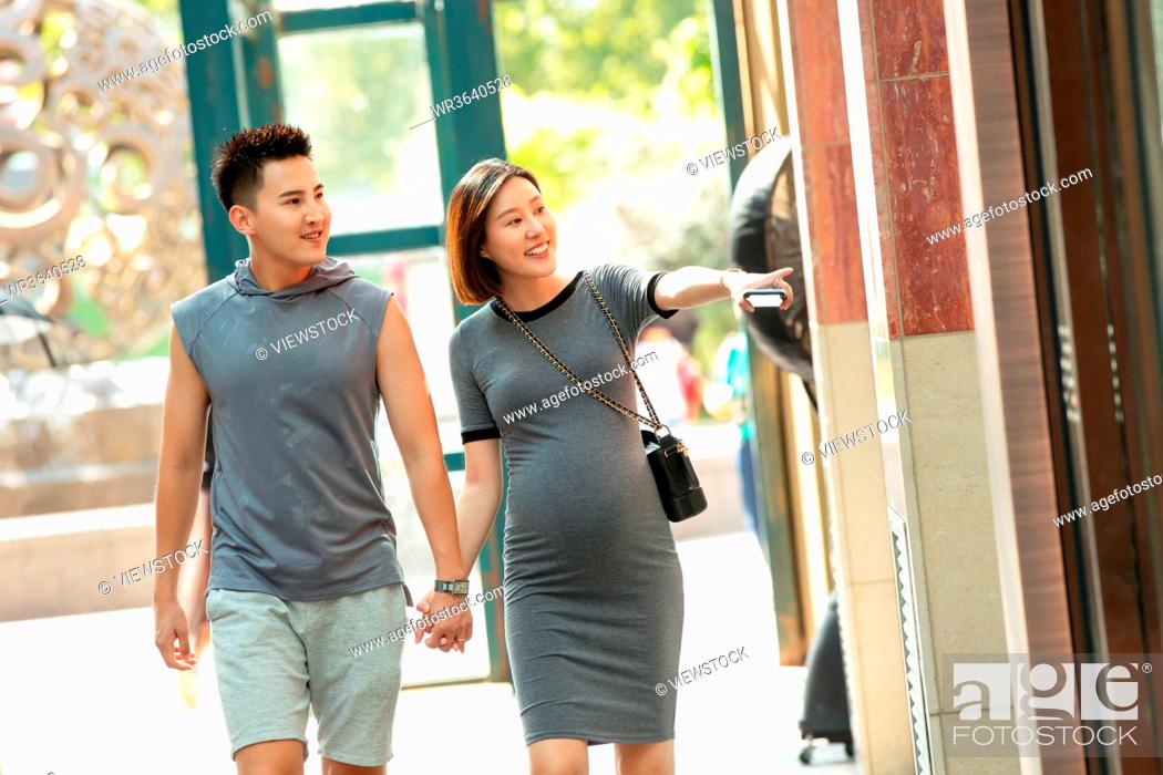 Stock Photo: Her husband with his pregnant wife to go shopping shopping.