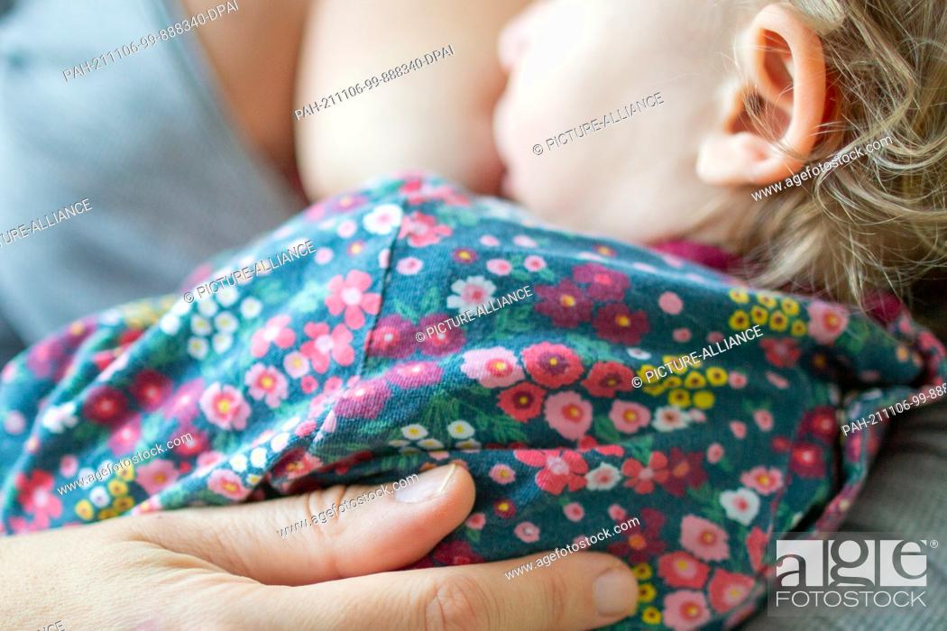 Stock Photo: PRODUCTION - 29 October 2021, Berlin: A mother breastfeeds her infant. Already in the womb, the basis is laid for what you will taste later.
