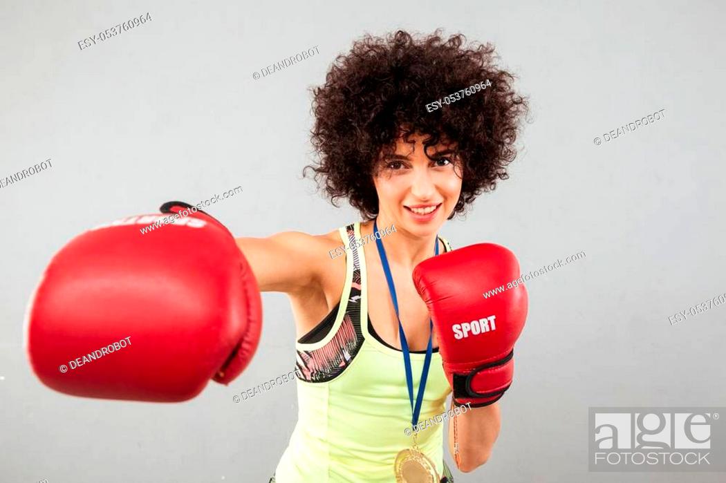 Photo de stock: Smiling carefree sports woman boxing at the camera over gray background.