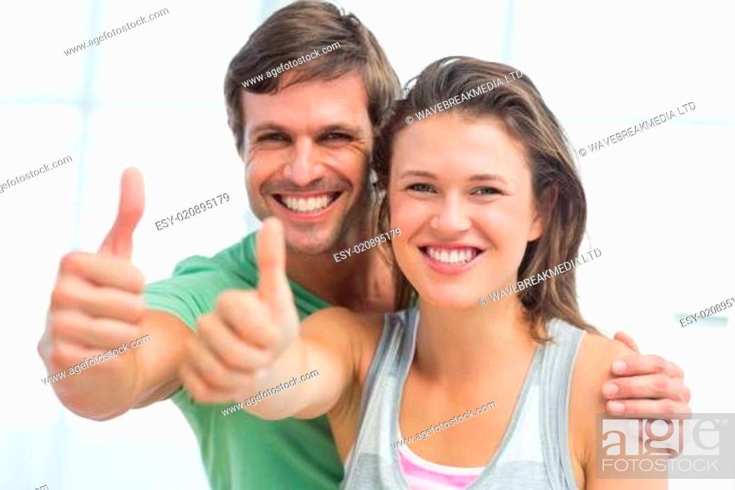 Photo de stock: Portrait of a fit young couple gesturing thumbs up.