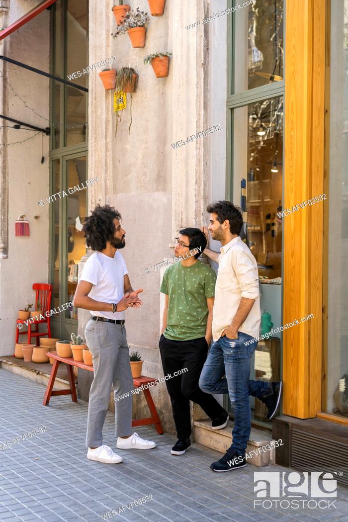 Stock Photo: Three young men talking in the city.