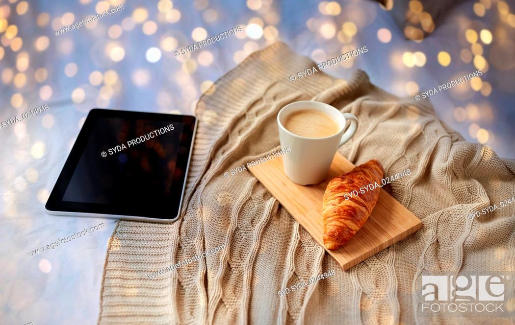 Stock Photo: tablet pc, coffee and croissant on bed at home.