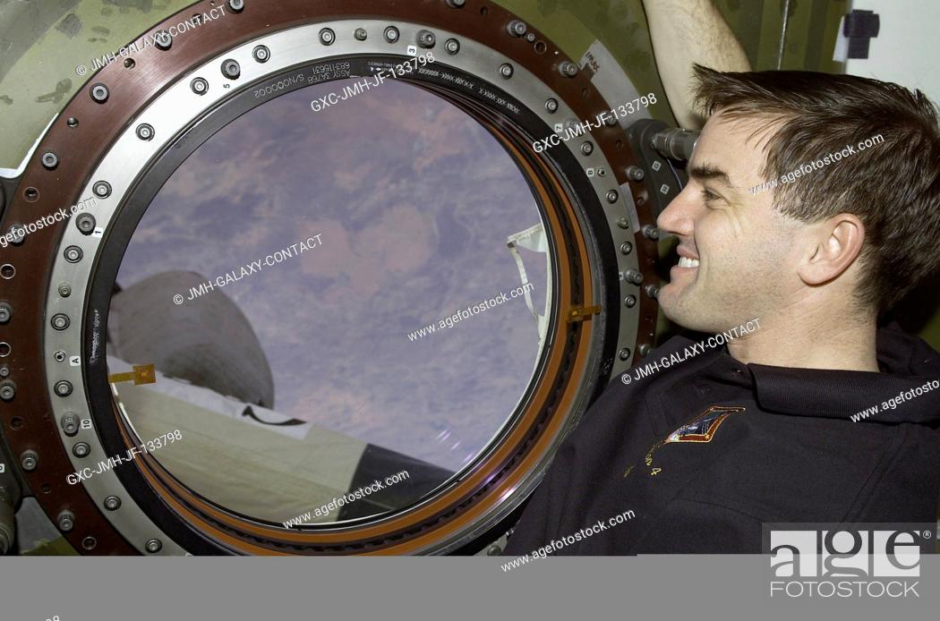 Stock Photo: Astronaut Rex J. Walheim, STS-110 mission specialist, looks through the Earth observation window in the Destiny laboratory on the International Space Station.