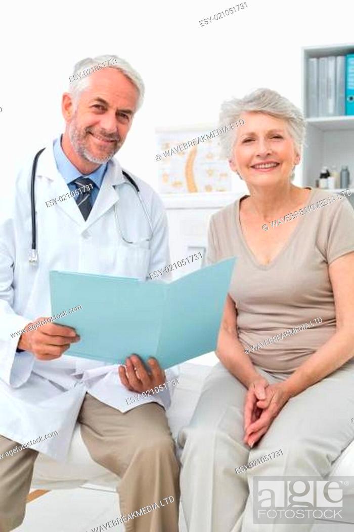 Stock Photo: Male doctor and senior patient with reports.