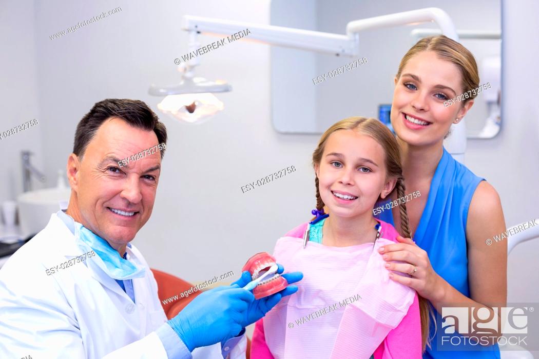 Stock Photo: Portrait of dentist with young patient and his mother.