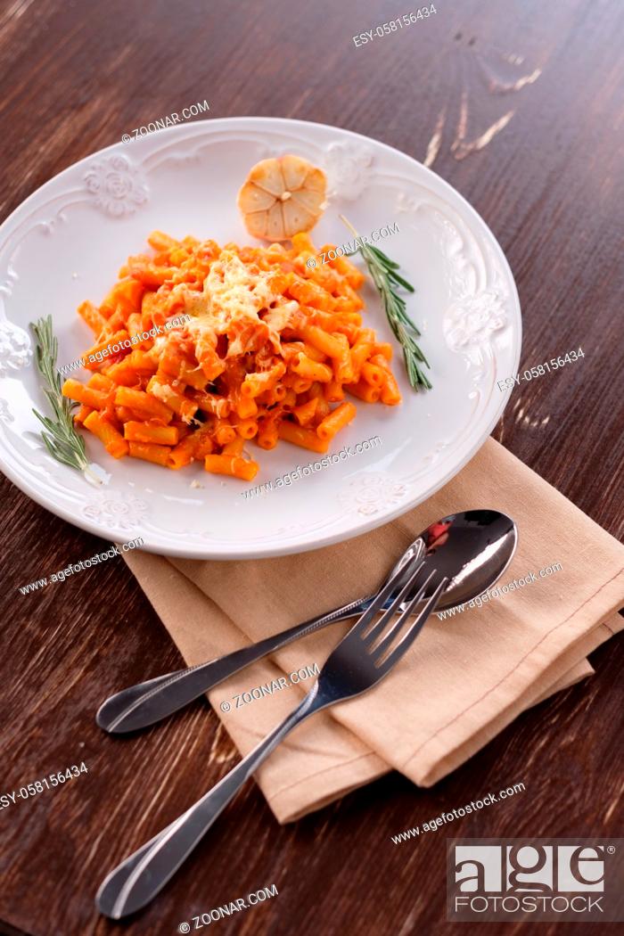 Stock Photo: Italian pasta with tomato cheese and garlic. Close-up on a plate with melted cheese.