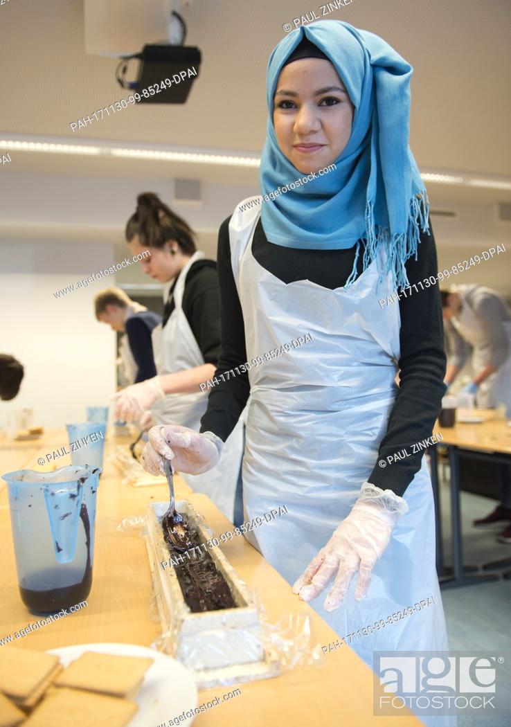 Stock Photo: Shahad, a student at the Philipp Reis School in Berlin's Lichtenberg, helping in the production of a giant hedgehog slice in Berlin, Germany, 30 November 2017.