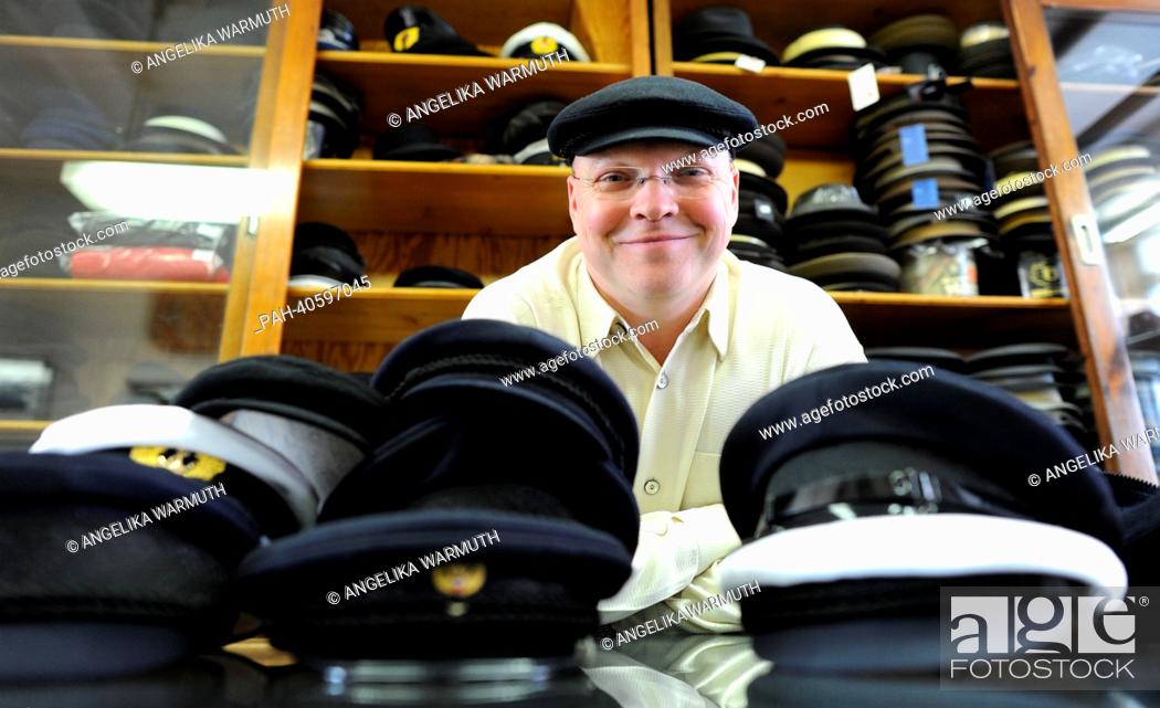 Stock Photo: Cap maker Lars Kuentzel stands behind the counter in Hamburg, Germany, 15 March 2013. Since 1892 the cap shop Eisenberg produces and sells caps called Altona.