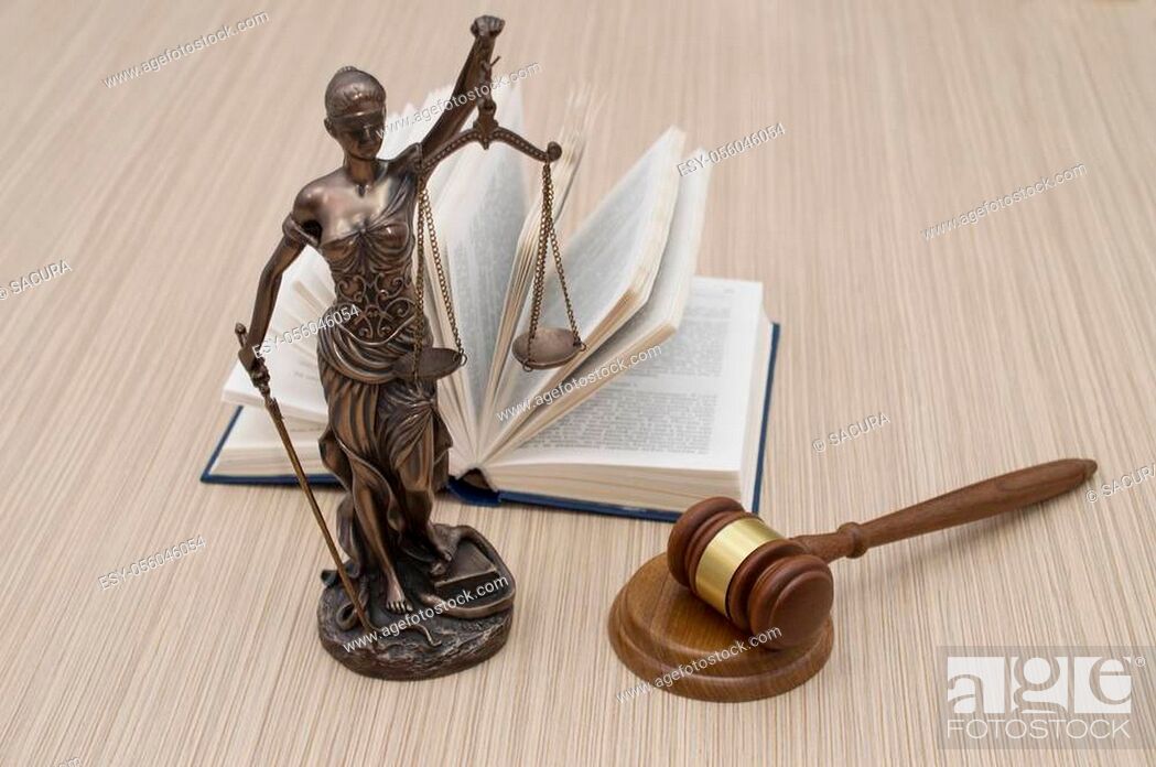 Stock Photo: statue of justice on wooden table against the background of an open book.