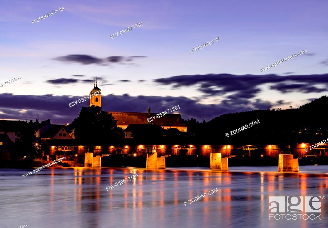 Stock Photo: Bad Saeckingen, BW / Germany - 4 July 2020: view of the St. Fridolin cathedral and Rhine bridge in Bad Saeckingen at sunset.