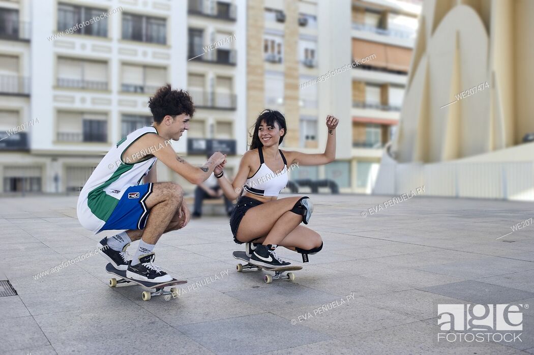 Stock Photo: Two young people riding on skateboard in the city.