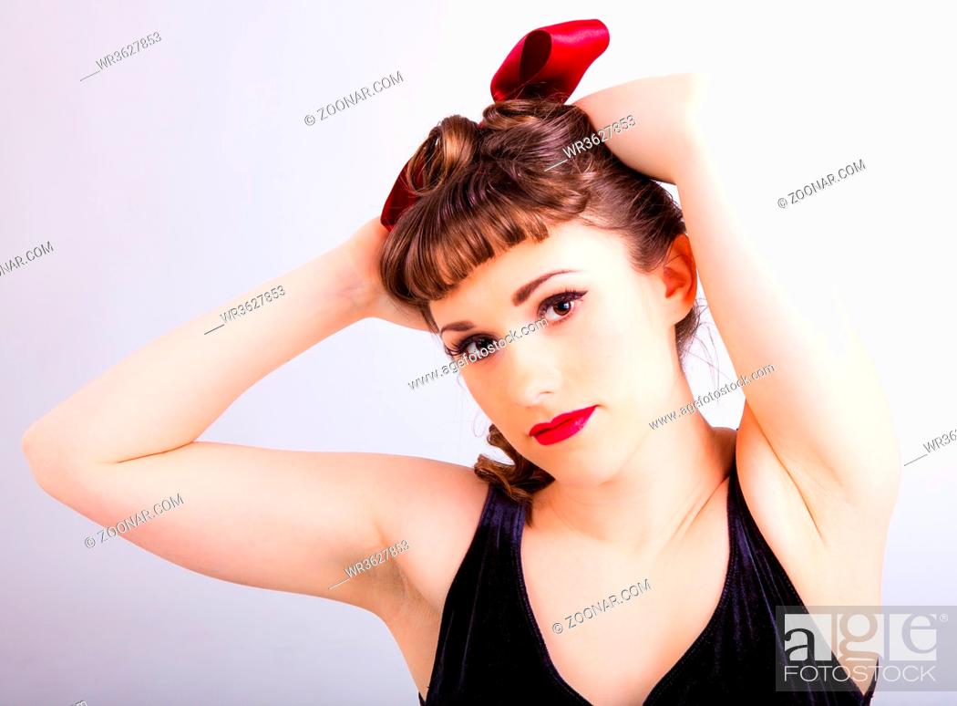 Stock Photo: young girl in fifties pin-up style with a red hair ribbon.