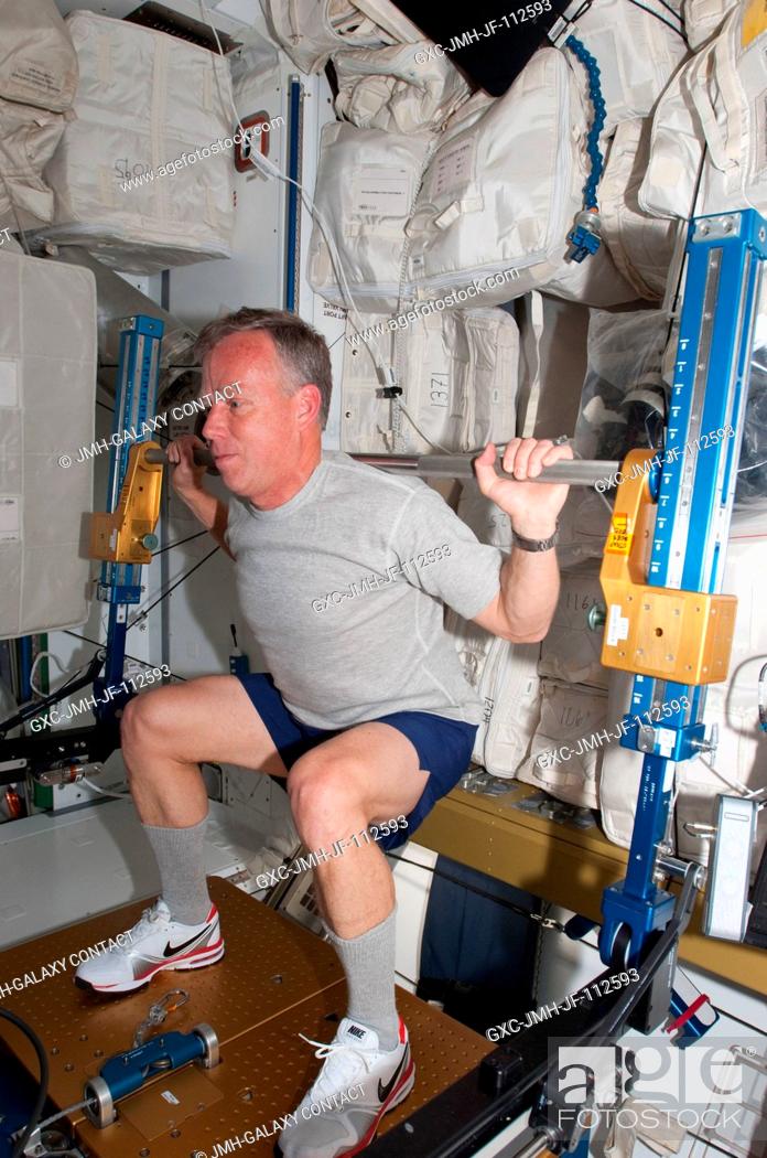 Stock Photo: NASA astronaut Steve Lindsey, STS-133 commander, exercises using the advanced Resistive Exercise Device (aRED) in the Tranquility node of the International.