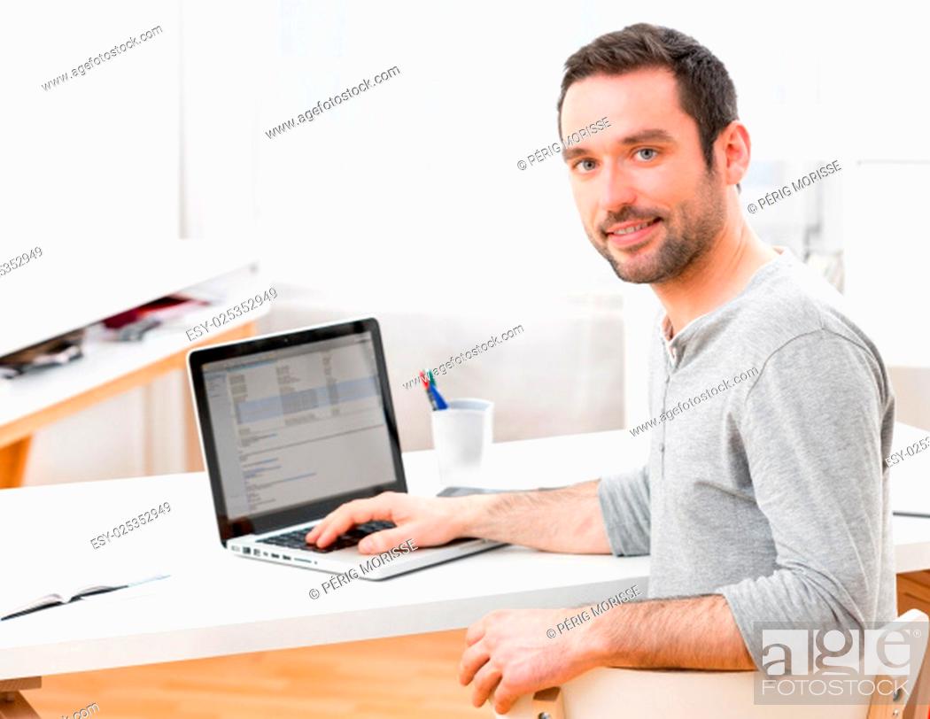 Stock Photo: View of a Young smiling man in front of a computer.