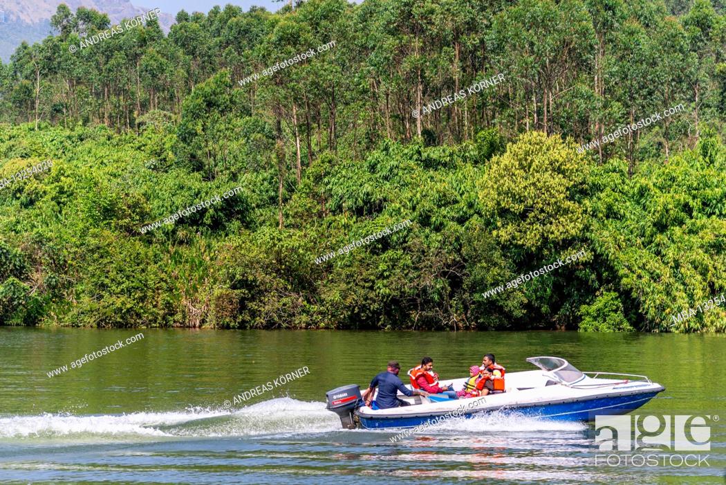 Stock Photo: Motorboat drives over lake, jungle,.