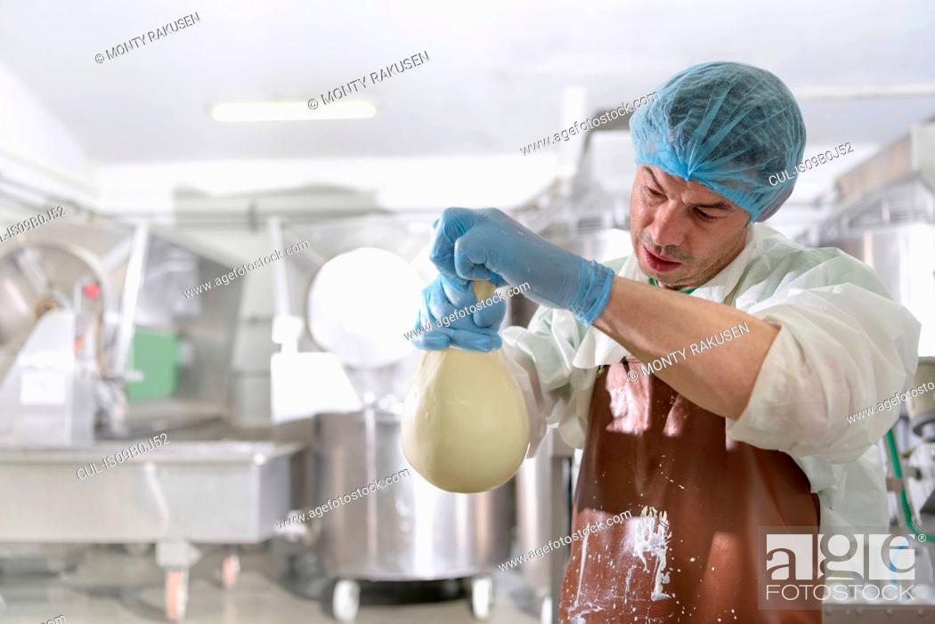 Stock Photo: Worker hand making mozzarella ball in cheese factory.