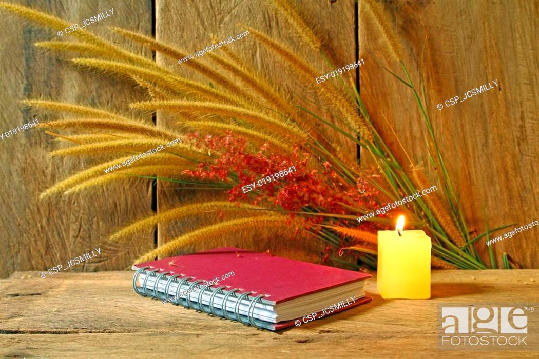 Stock Photo: Still life notebook and candle light with foxtail grass on grunge wooden background.