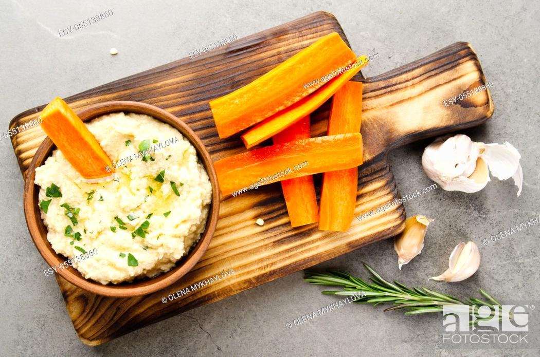 Stock Photo: Flat lay view at vegetable Hummus dip dish topped with olive oil served with carrot slices.