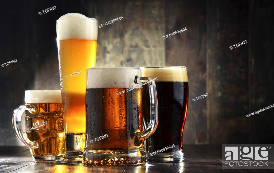 Stock Photo: Four glasses of beer on wooden background.