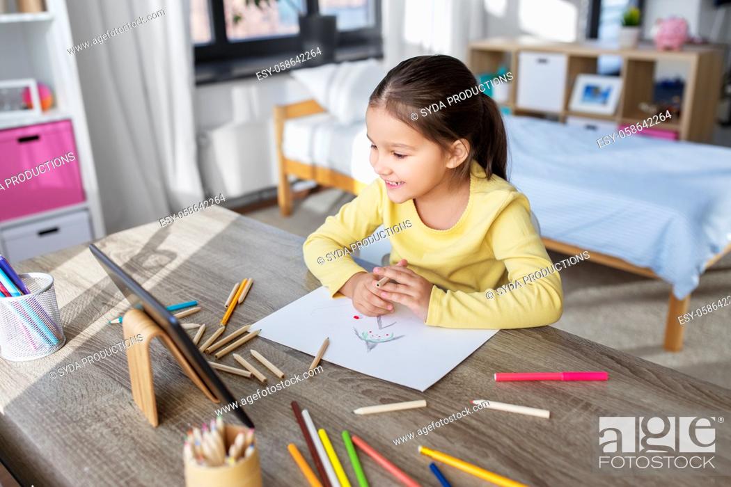 Stock Photo: little girl drawing with coloring pencils at home.