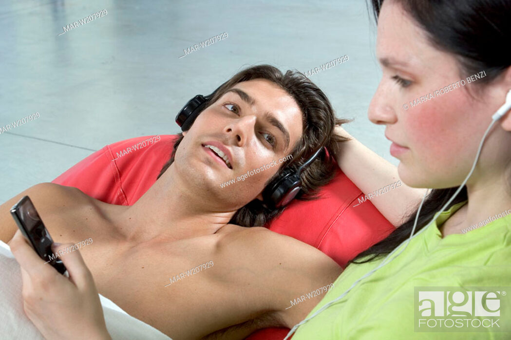 Imagen: young couple listening to MP3 player.